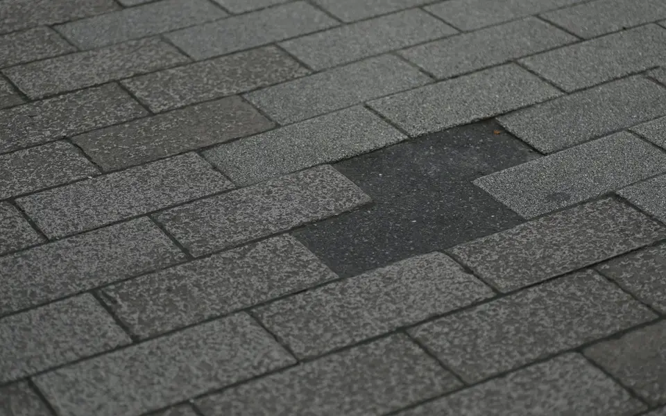 Close view of the textured surface and overlapping edges of asphalt shingles.