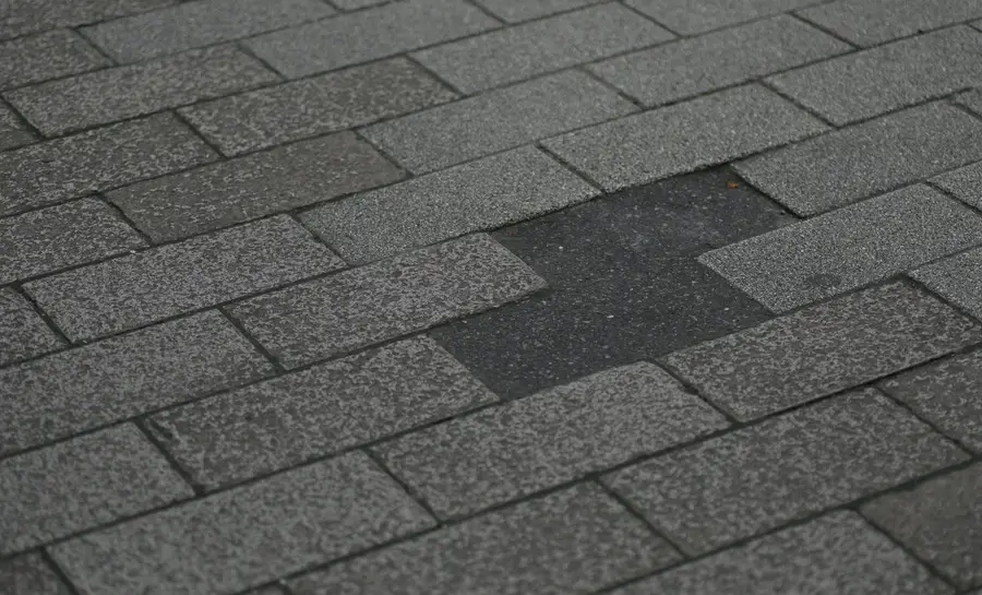Close view of the textured surface and overlapping edges of asphalt shingles.